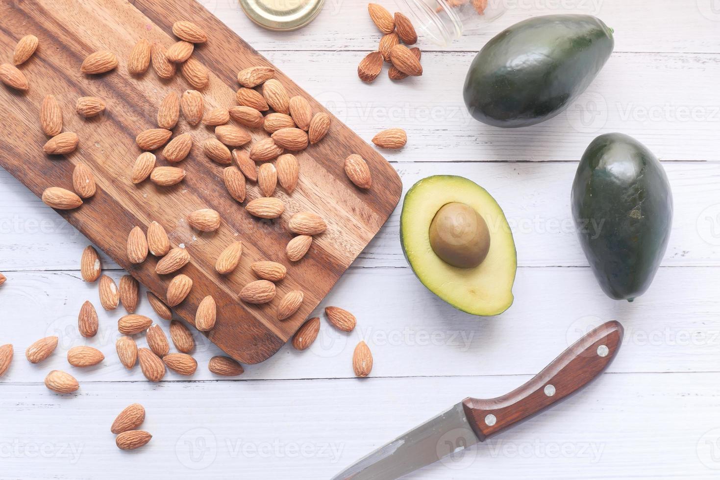 Rebanada de aguacate y almendras sobre una tabla de cortar foto