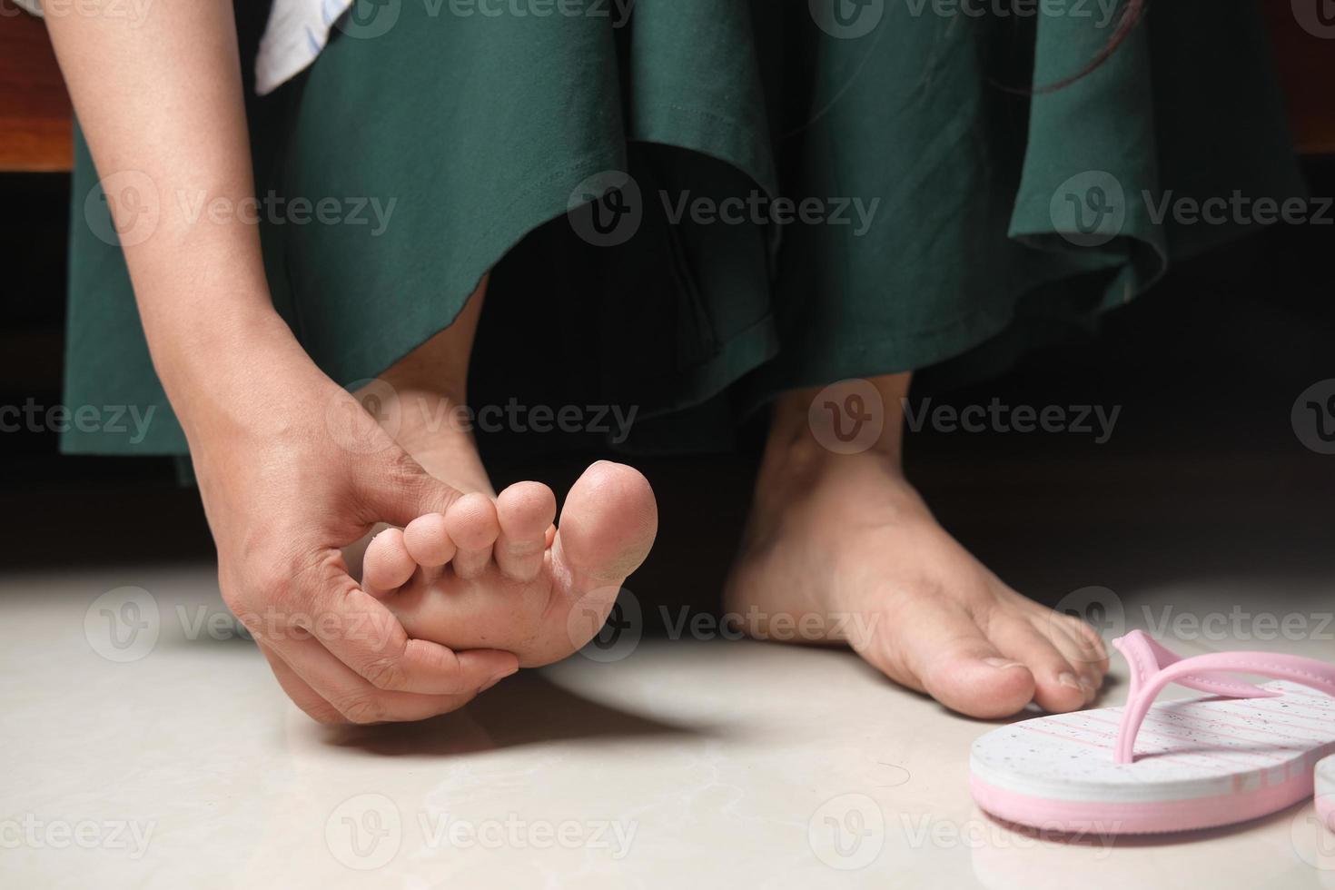 mujer masajeando pies foto