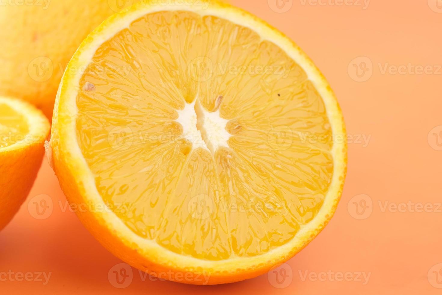 Close up of slice of orange fruit on orange background photo