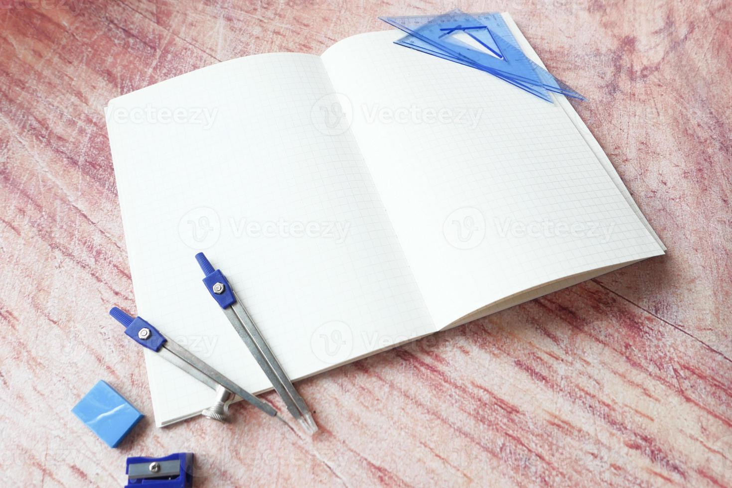 Open notebook with school supplies photo