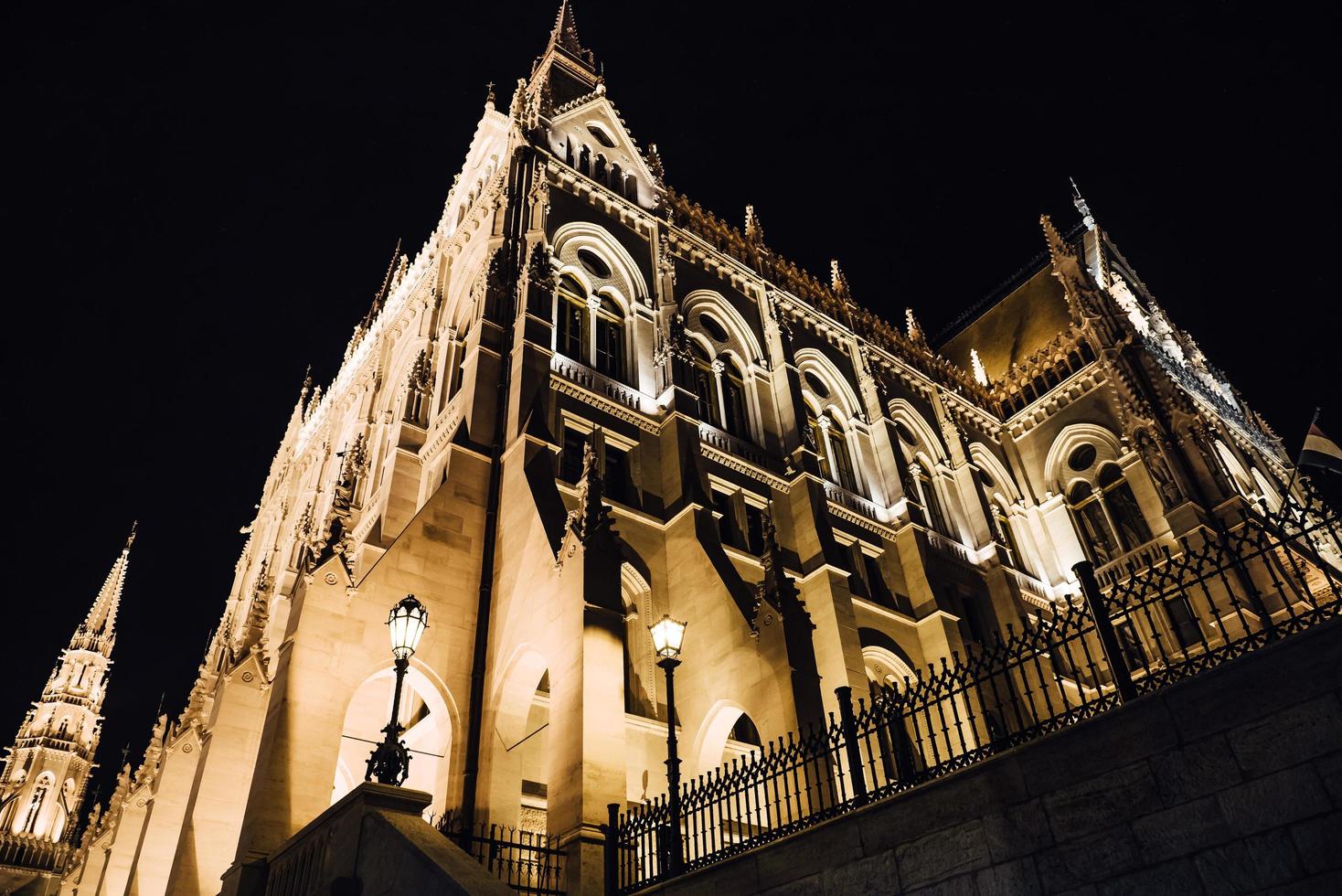 El parlamento húngaro en Budapest sobre el Danubio en las luces nocturnas de las farolas foto