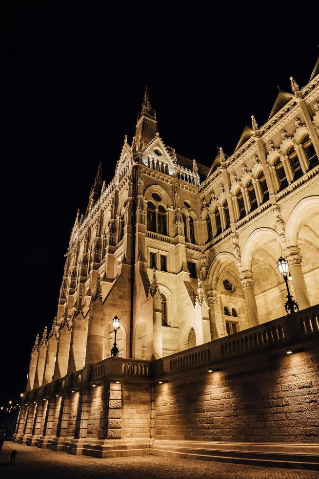 El parlamento húngaro en Budapest sobre el Danubio en las luces nocturnas de las farolas foto