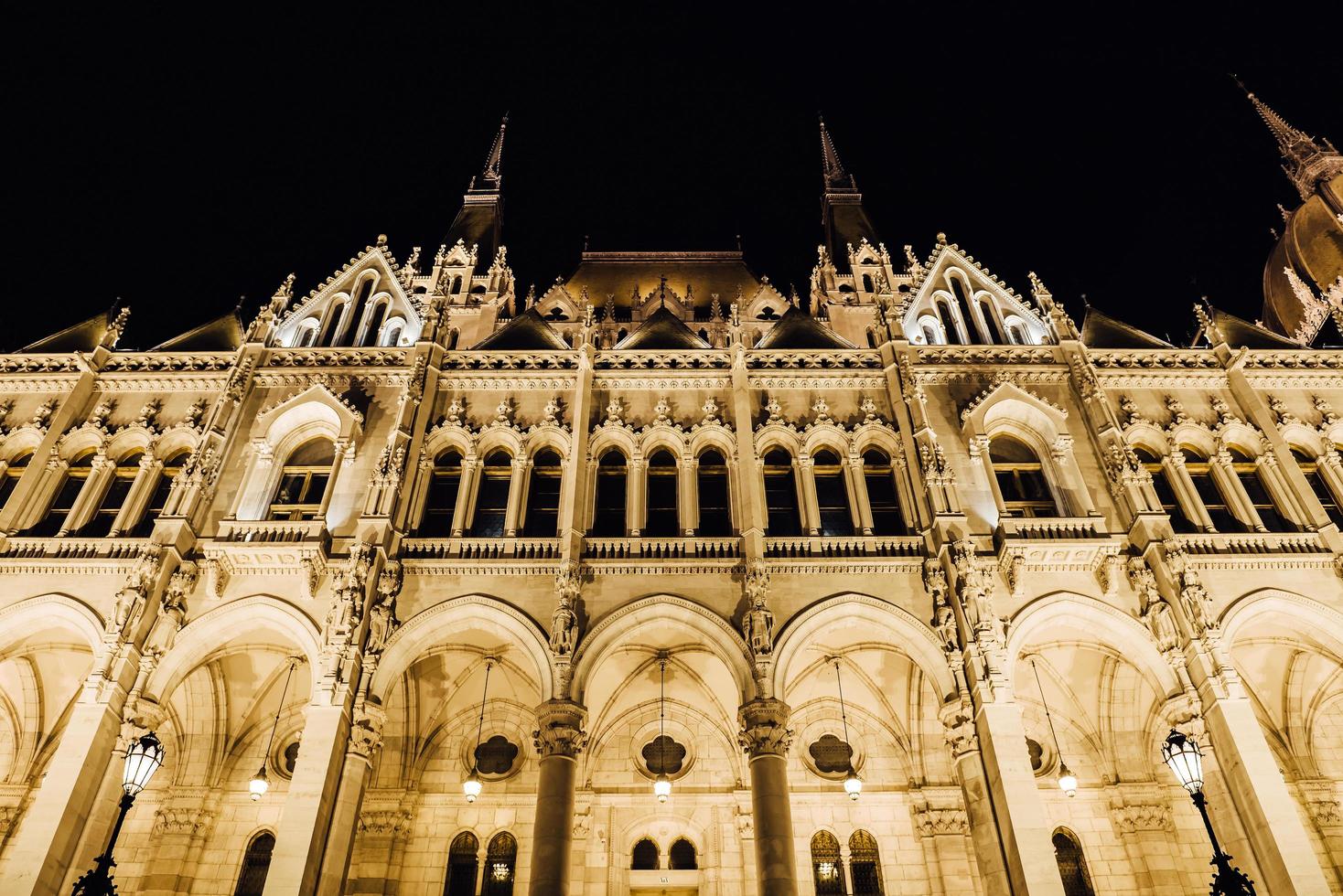 El parlamento húngaro en Budapest sobre el Danubio en las luces nocturnas de las farolas foto