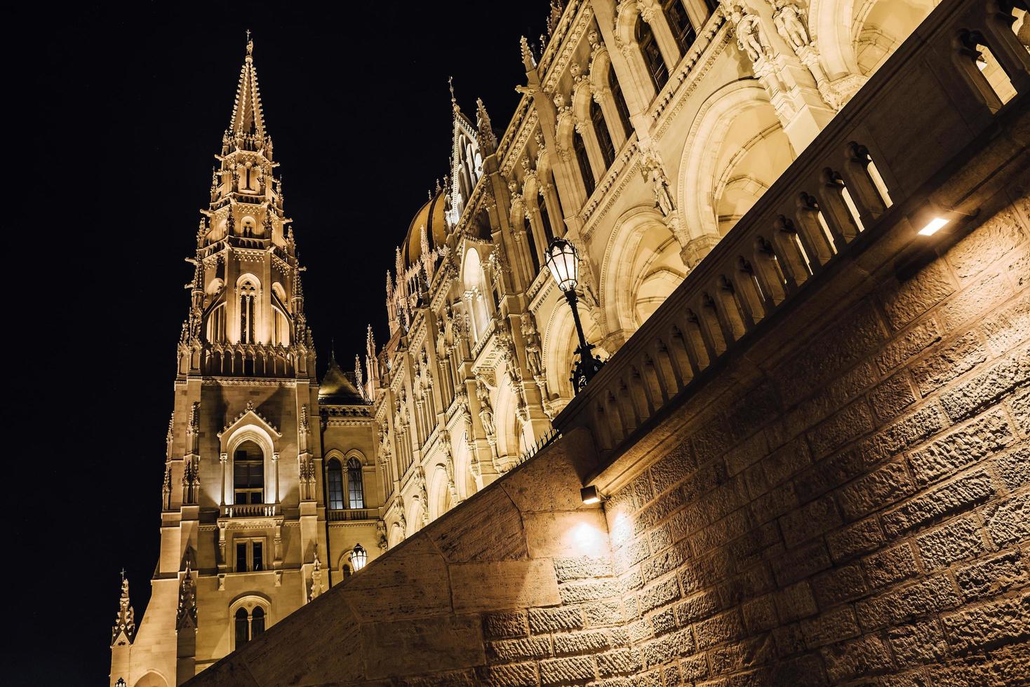 El parlamento húngaro en Budapest sobre el Danubio en las luces nocturnas de las farolas foto