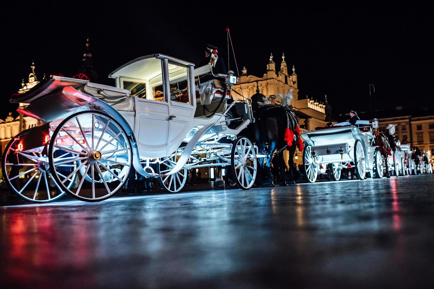 Cracovia, Polonia 2017- la antigua plaza de la noche en Cracovia con carruajes tirados por caballos foto