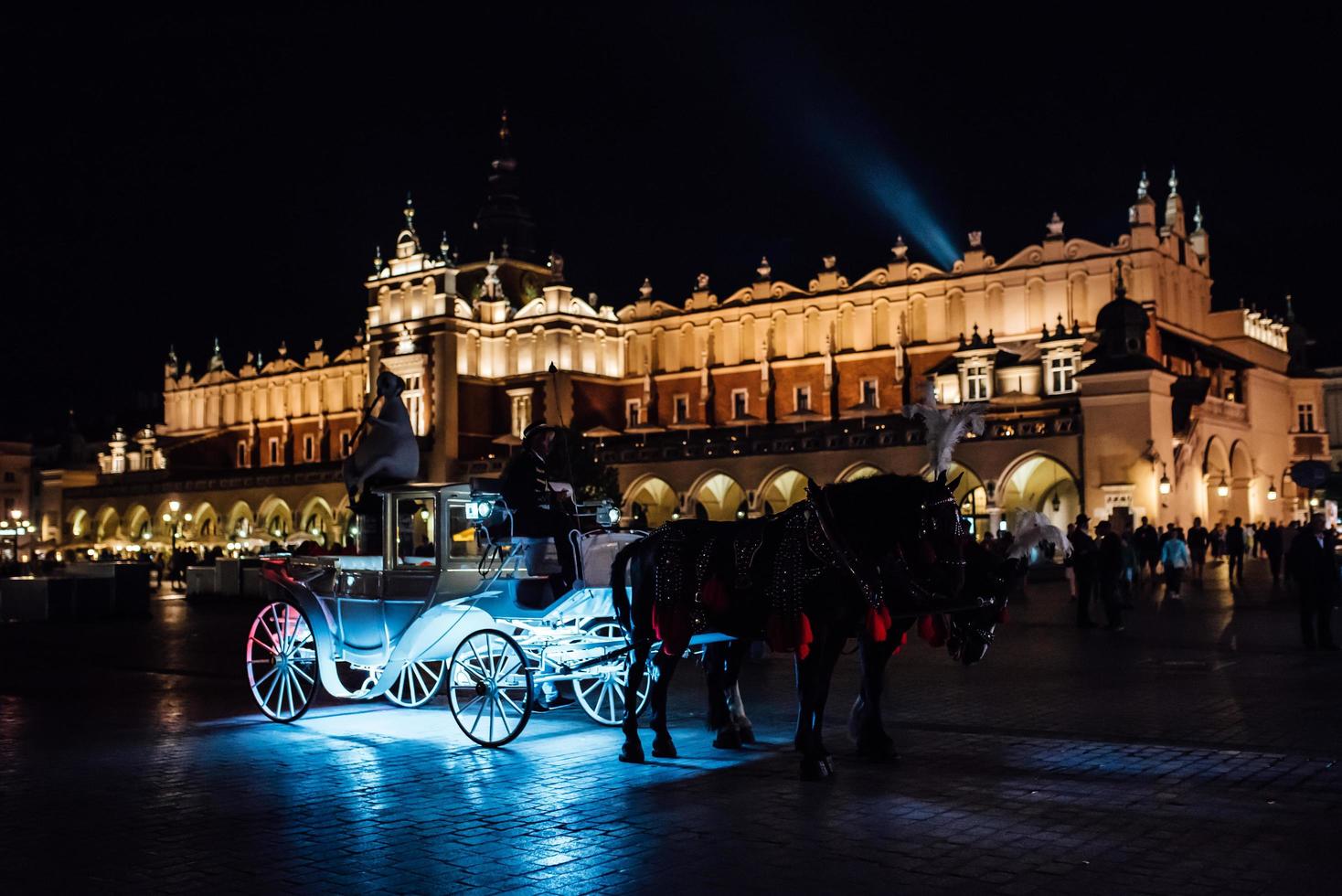 Cracovia, Polonia 2017- la antigua plaza de la noche en Cracovia con carruajes tirados por caballos foto