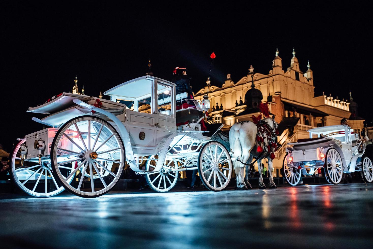 Cracovia, Polonia 2017- la antigua plaza de la noche en Cracovia con carruajes tirados por caballos foto