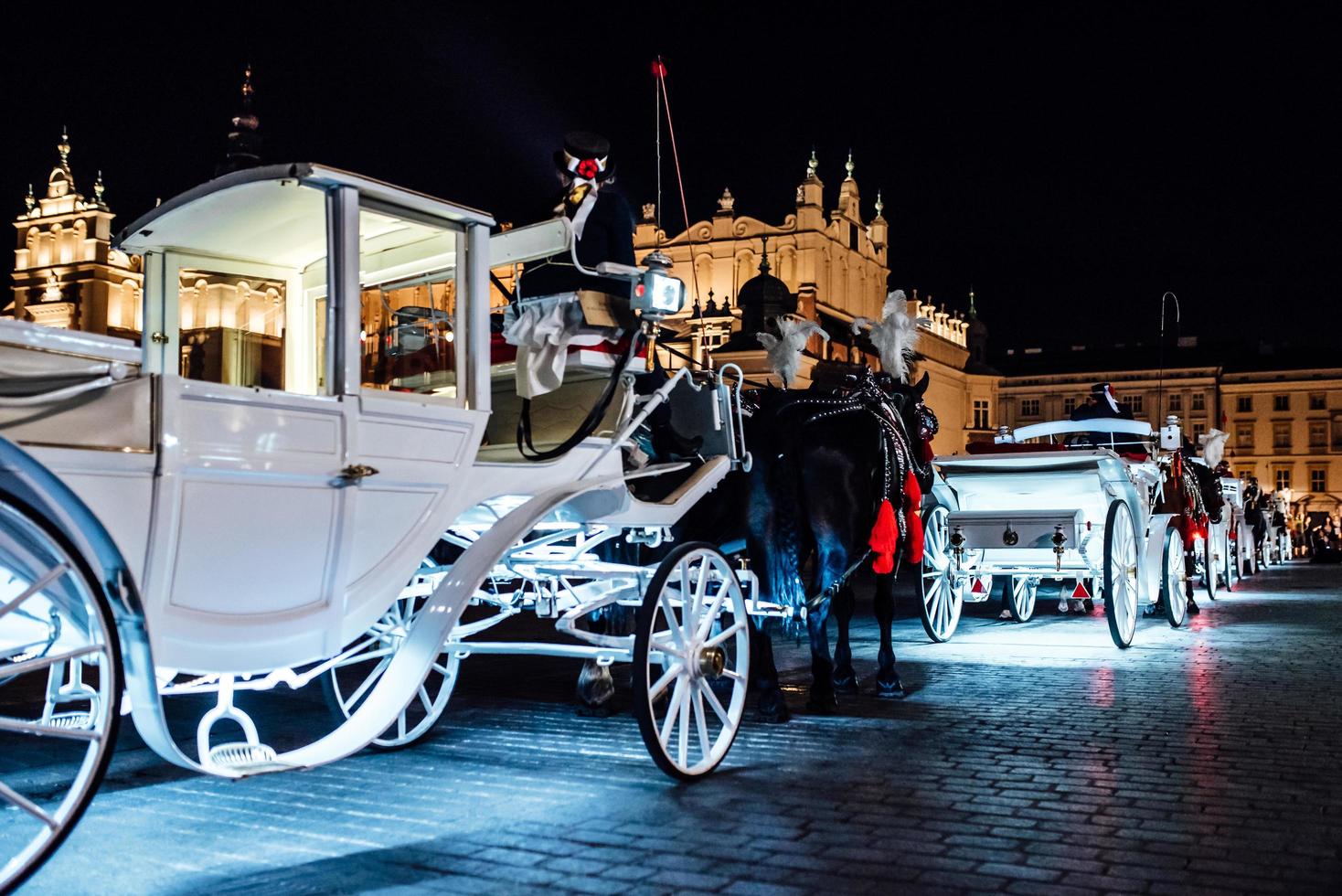 Cracovia, Polonia 2017- la antigua plaza de la noche en Cracovia con carruajes tirados por caballos foto