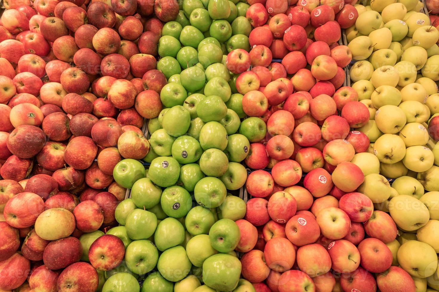 mostrador lleno de coloridas manzanas en diferentes colores foto