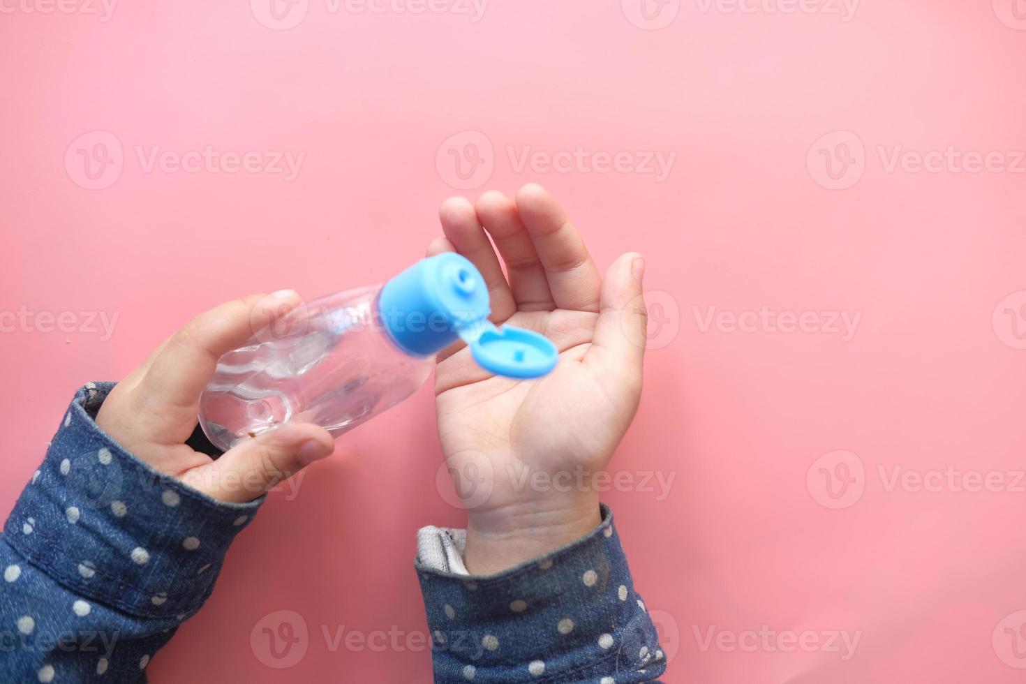 niño usando gel desinfectante para manos foto