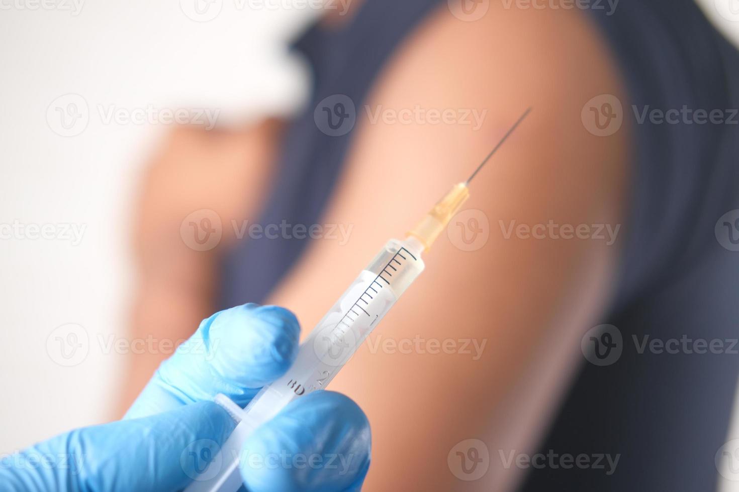 Doctor holding a syringe with blurred background photo