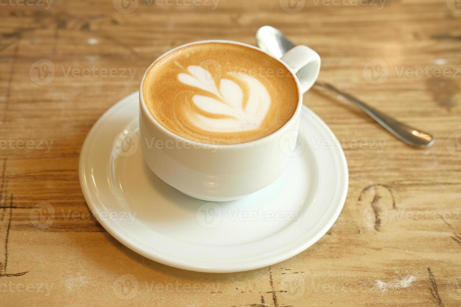 Latte with foam art on wood table photo