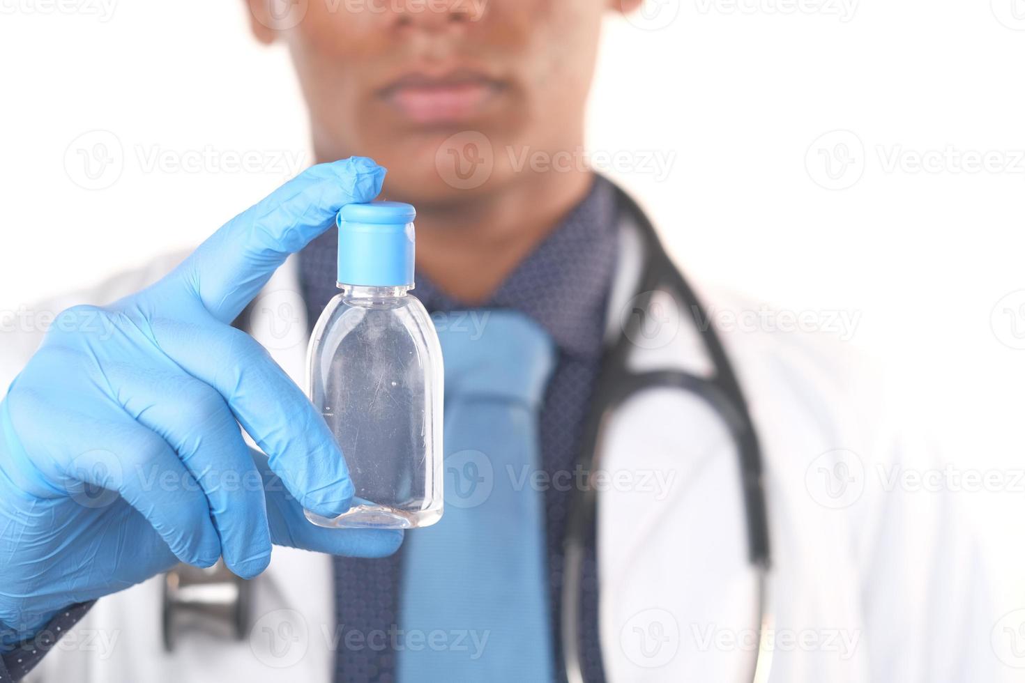 doctor sosteniendo una pequeña botella de desinfectante de manos foto