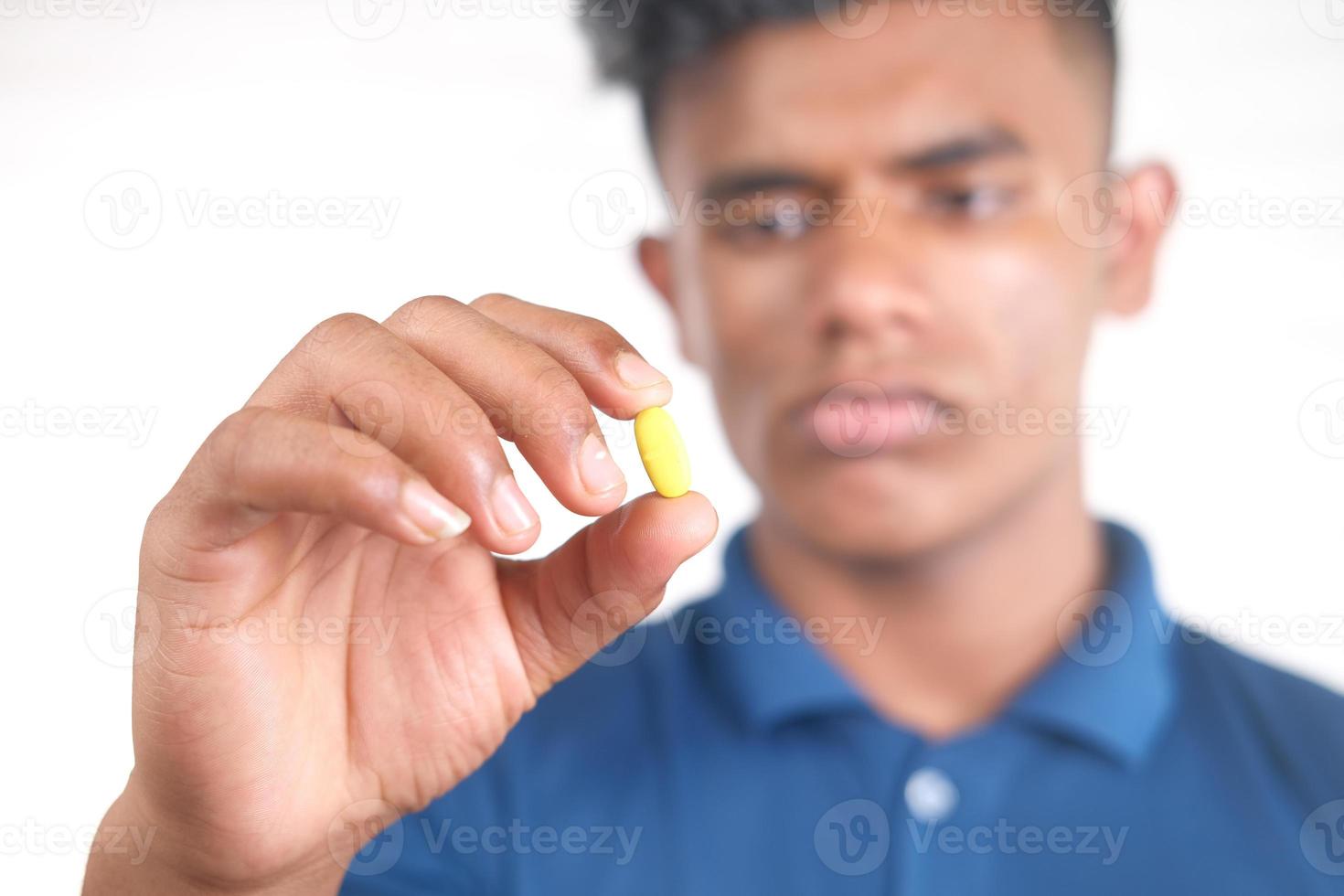 hombre sosteniendo una pequeña pastilla amarilla foto