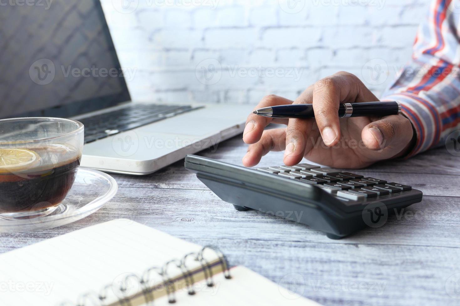 Hombre usando calculadora sobre fondo neutro foto