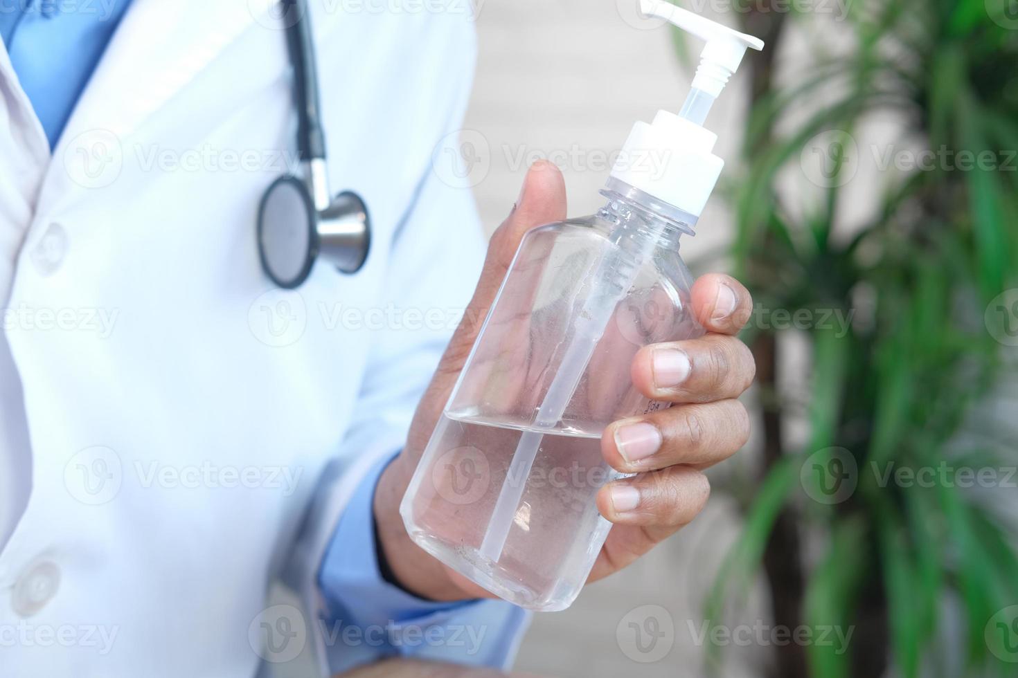 doctor sosteniendo una botella de desinfectante de manos foto