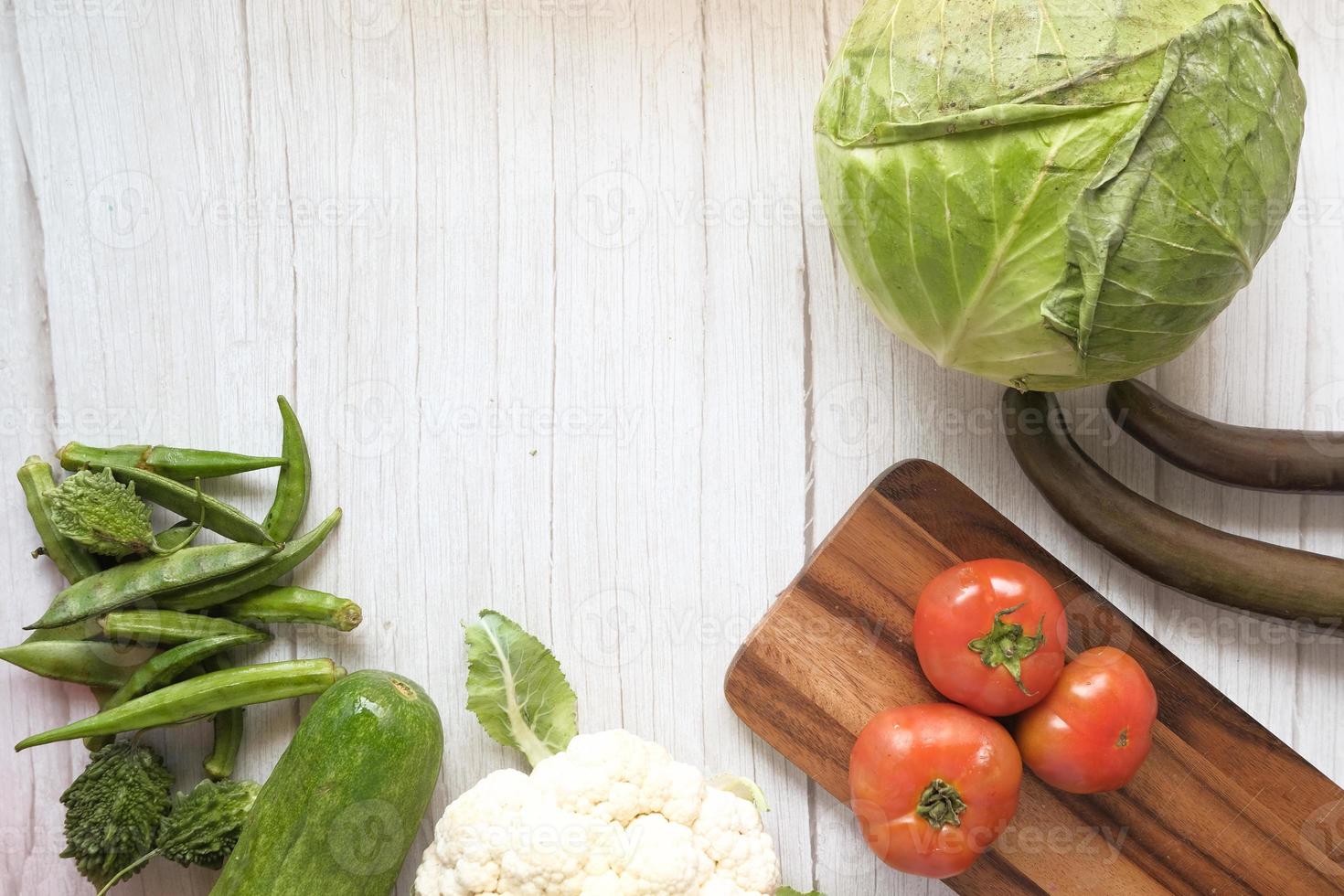 Selección de alimentos saludables con verduras frescas en una tabla de cortar foto