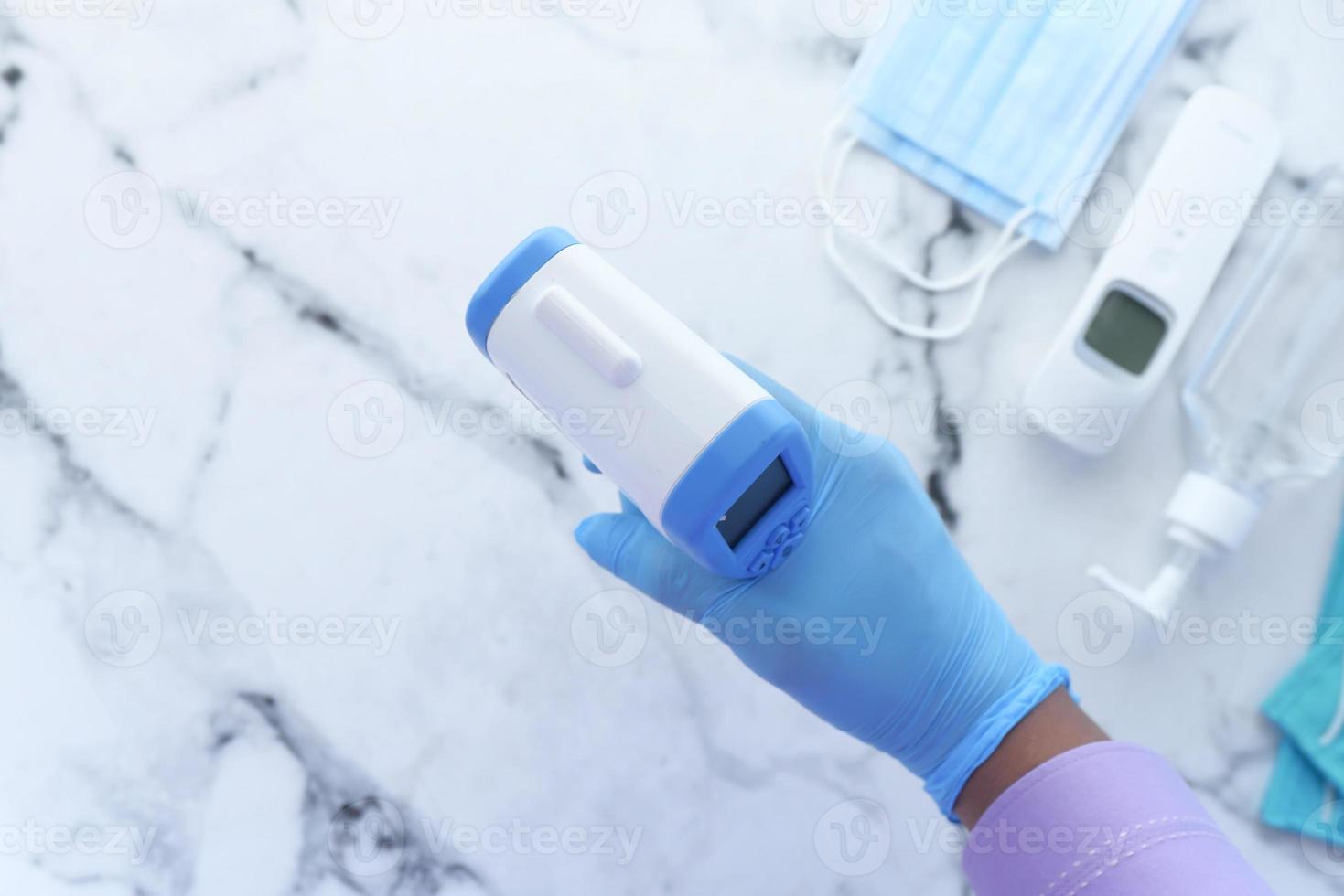 Hand holding infrared thermometer photo
