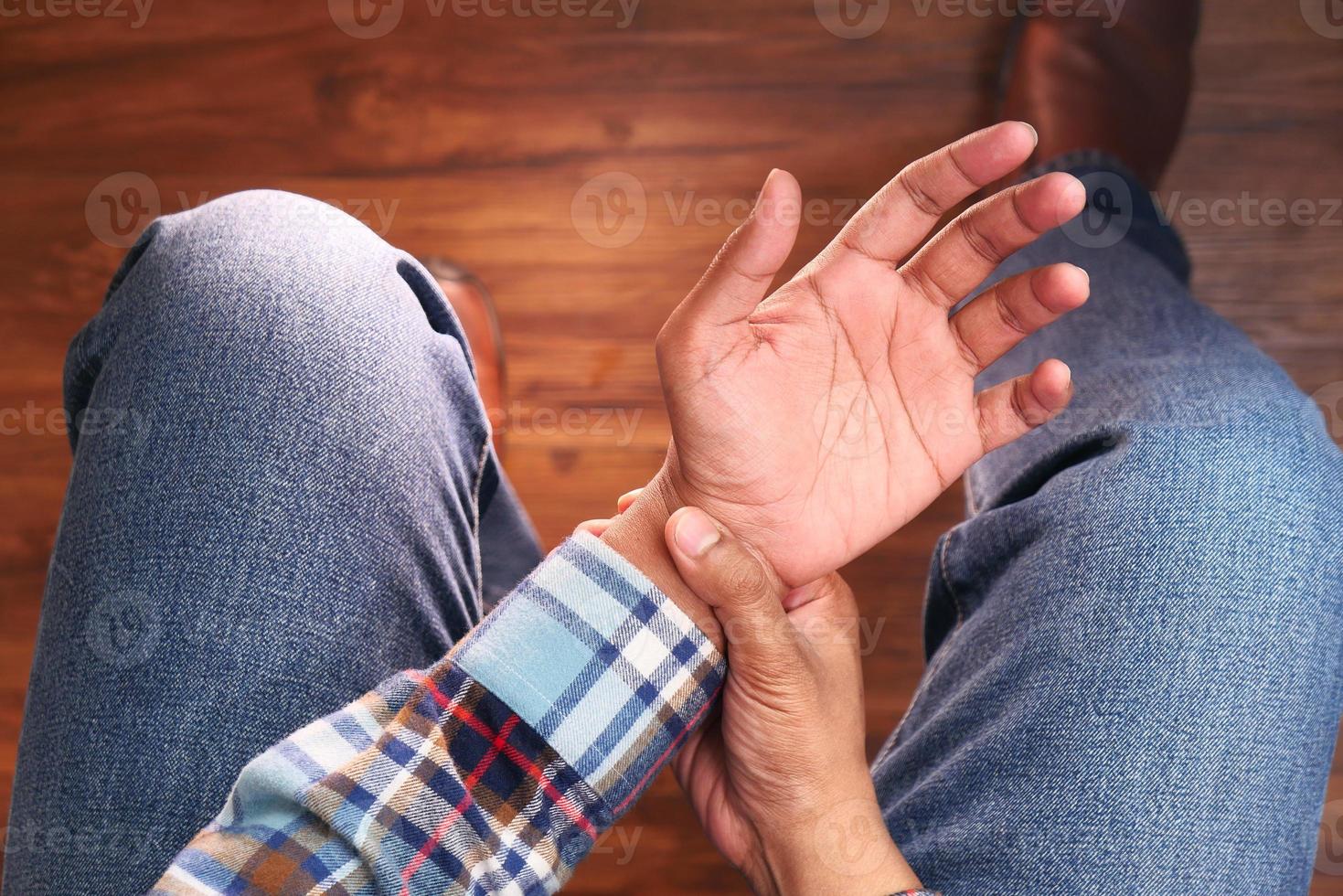 hombre sujetando la muñeca con dolor foto