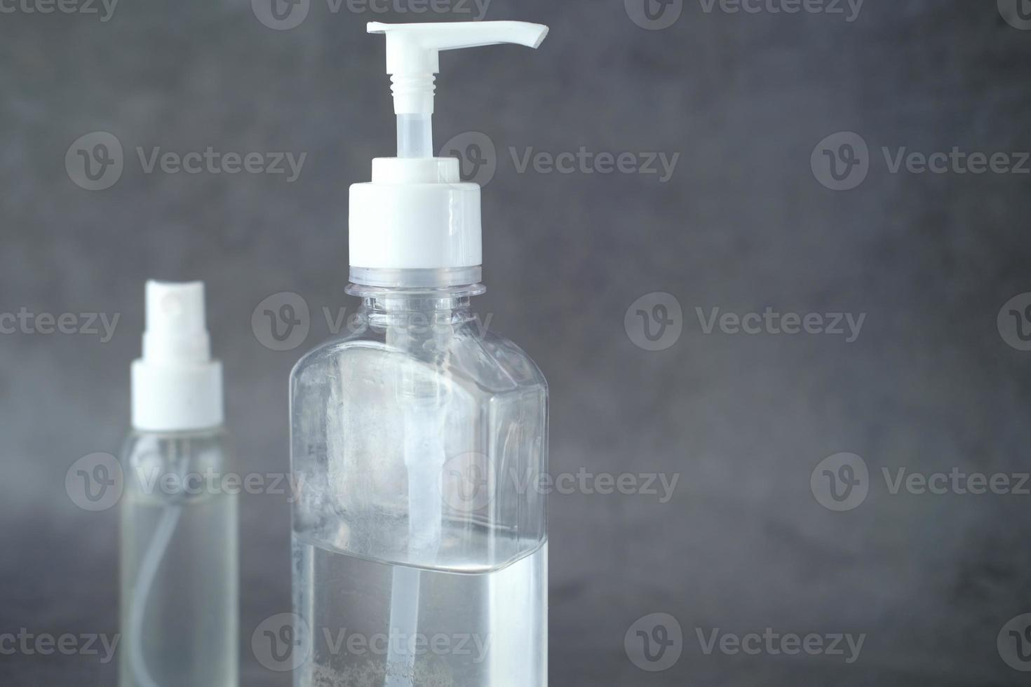 Two bottles of hand sanitizers on neutral grey background photo