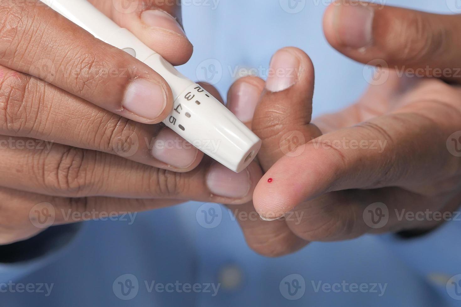 hombre midiendo el nivel de glucosa foto