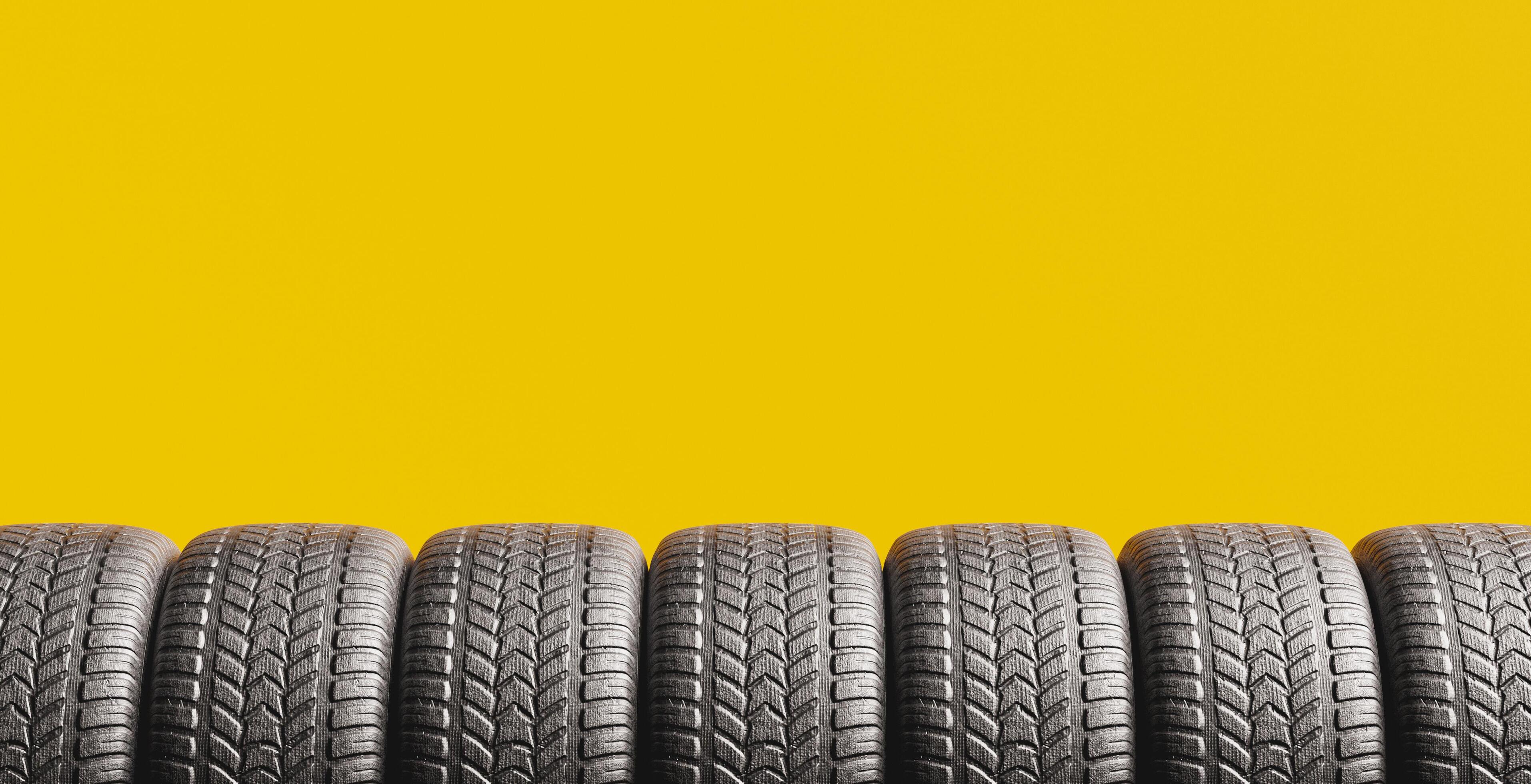fondo amarillo con una hilera de neumáticos 2172116 Foto de stock en