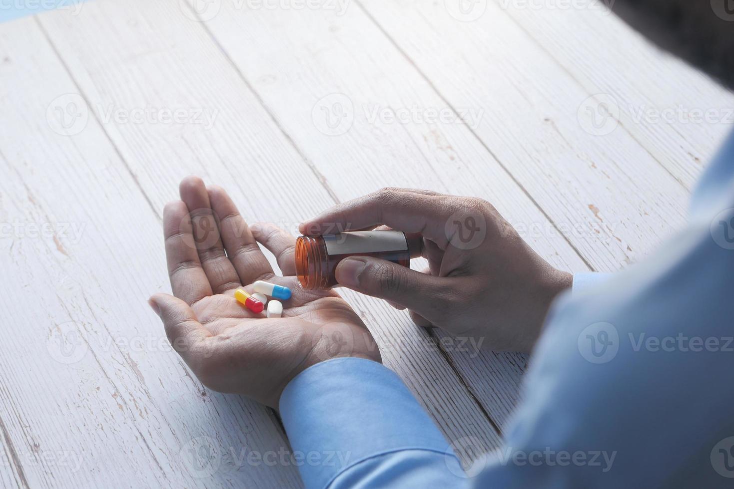hombre tomando pastillas foto