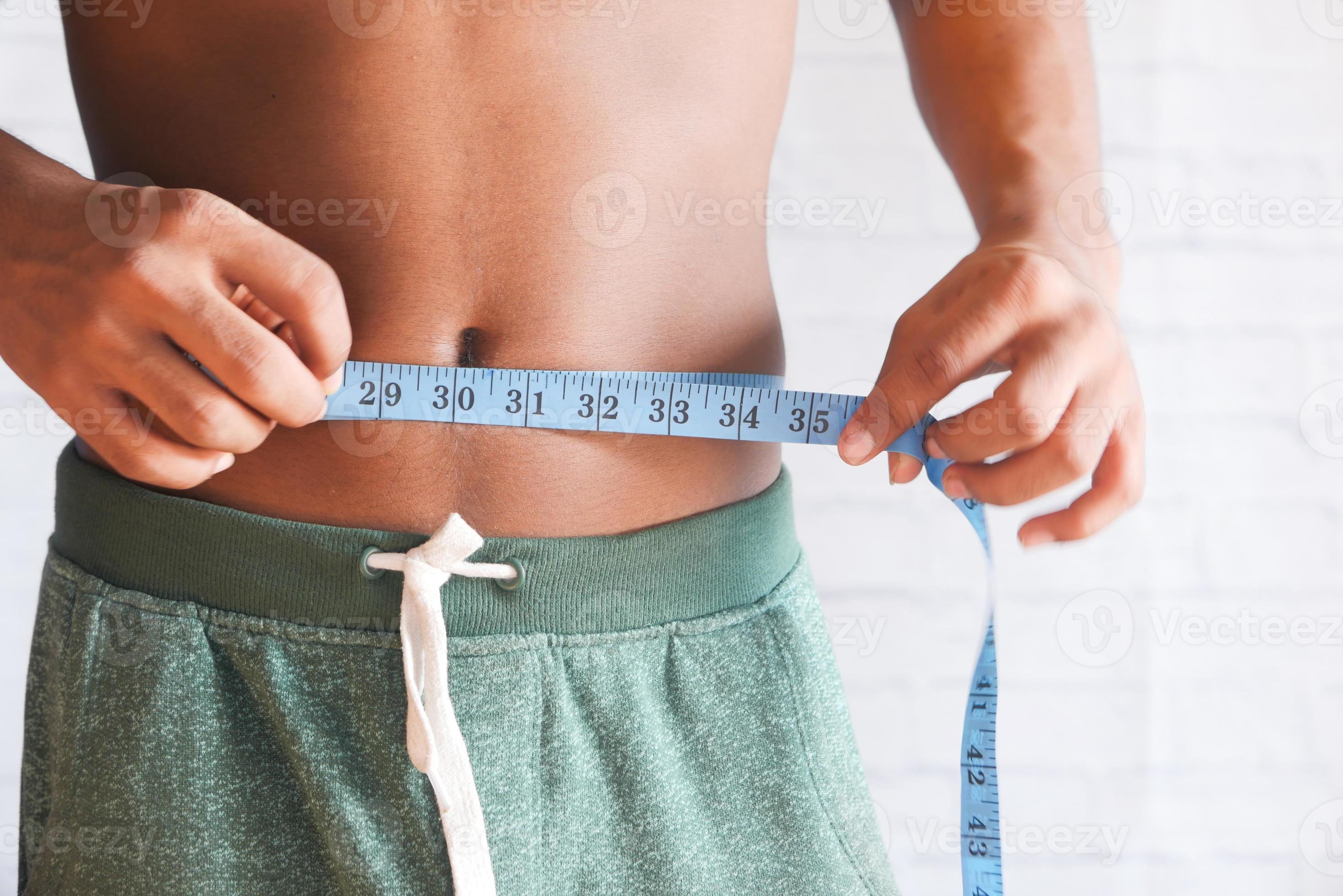 young-man-measuring-his-waist-2173924-stock-photo-at-vecteezy