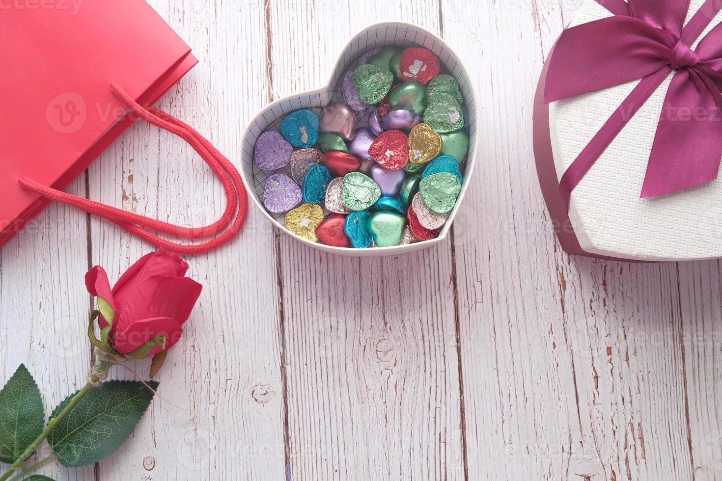 Heart shaped gift box with candy on table photo