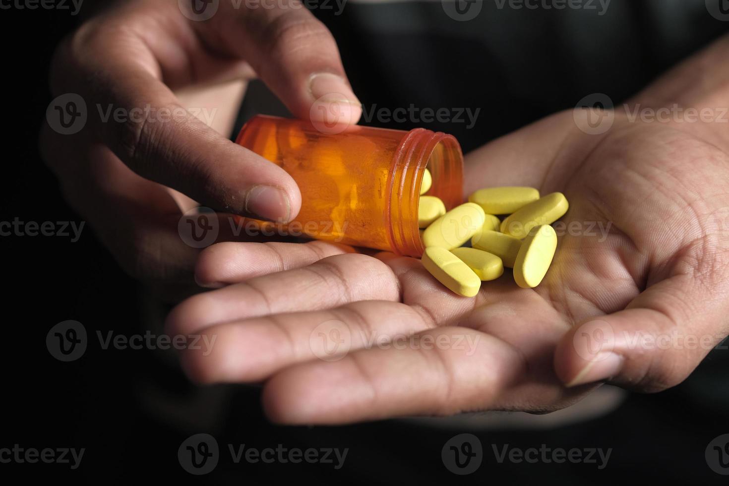 Yellow pills in palm of hand photo