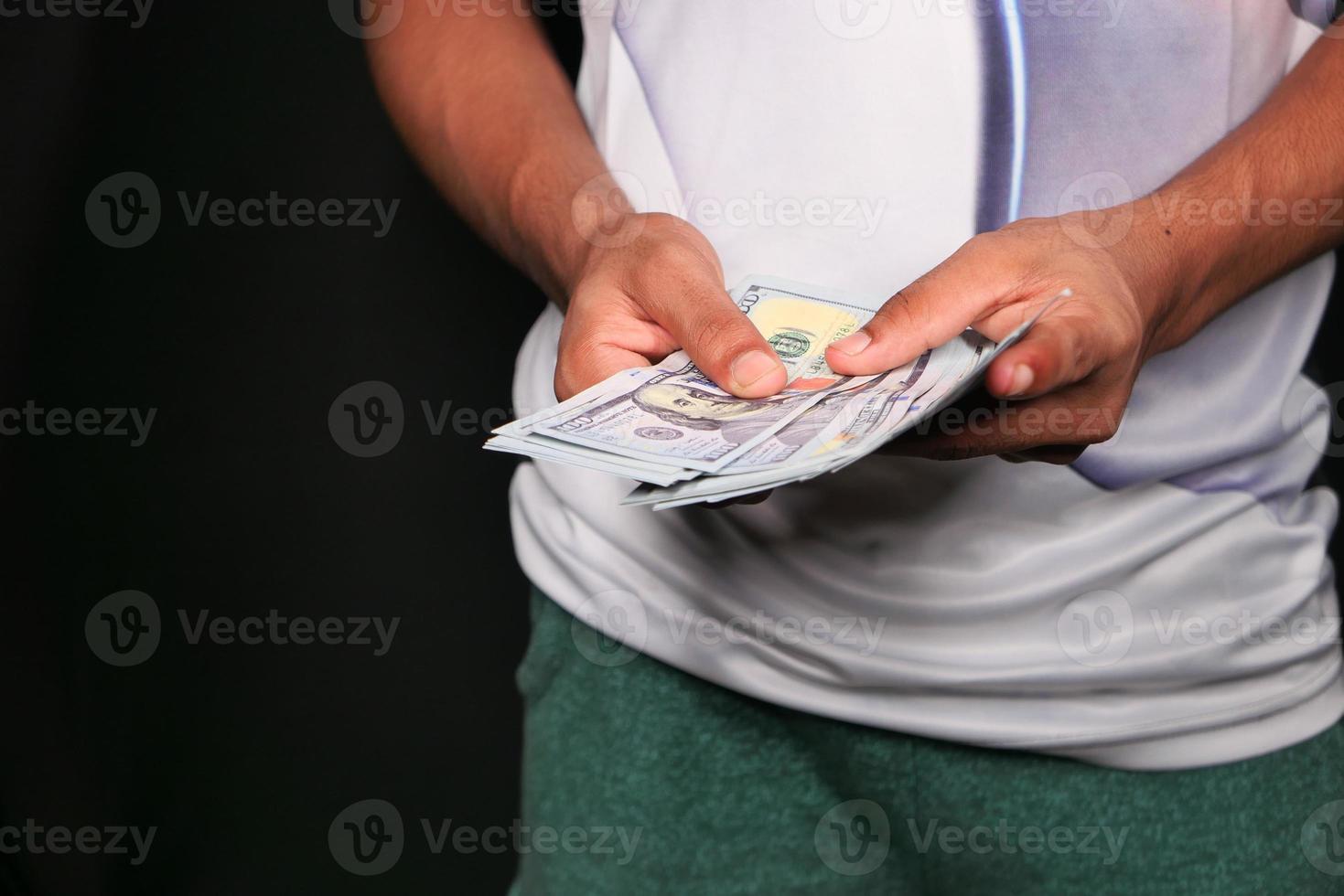 hombre contando efectivo sobre fondo negro foto