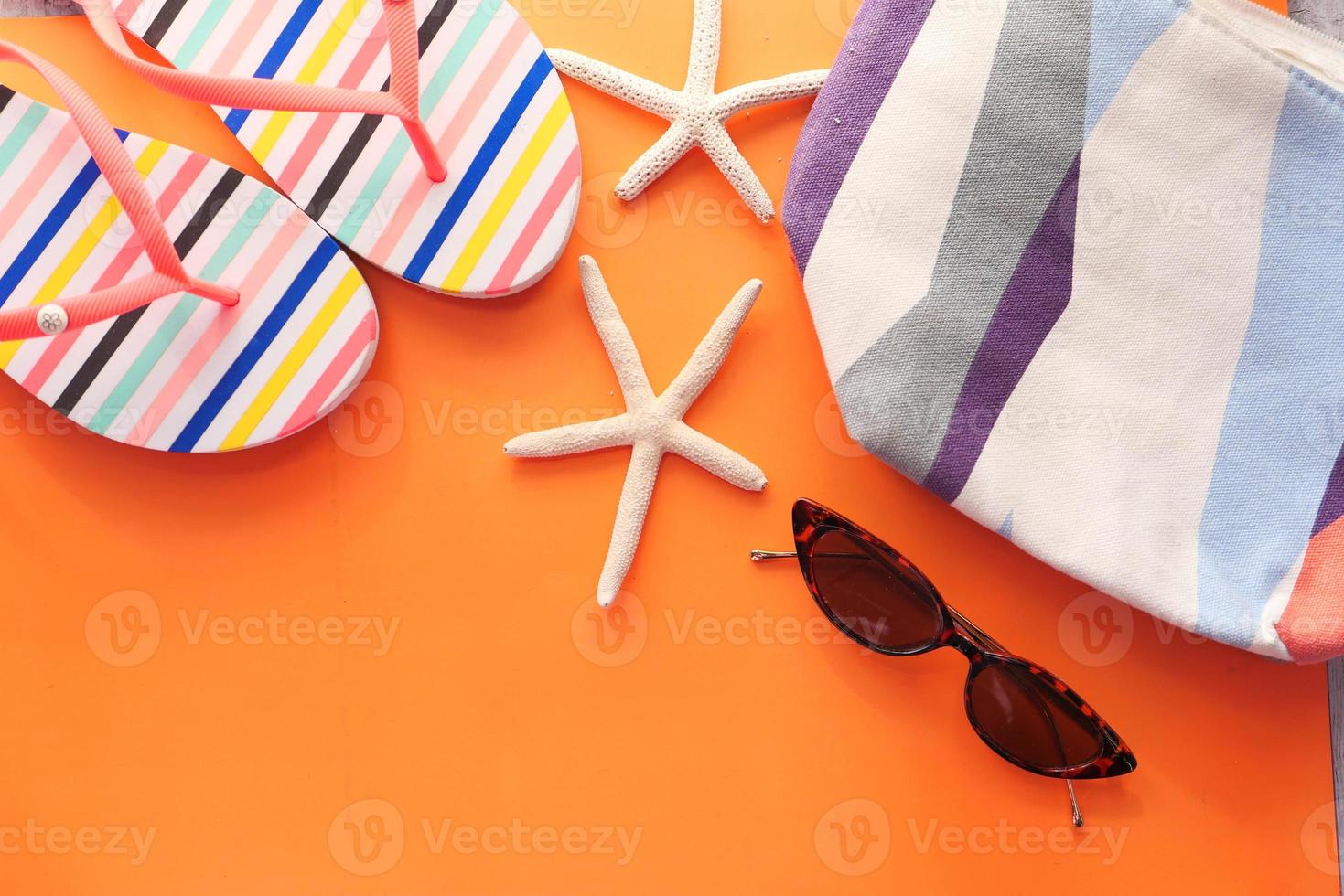 Flat composition of summer beach accessories on orange background photo