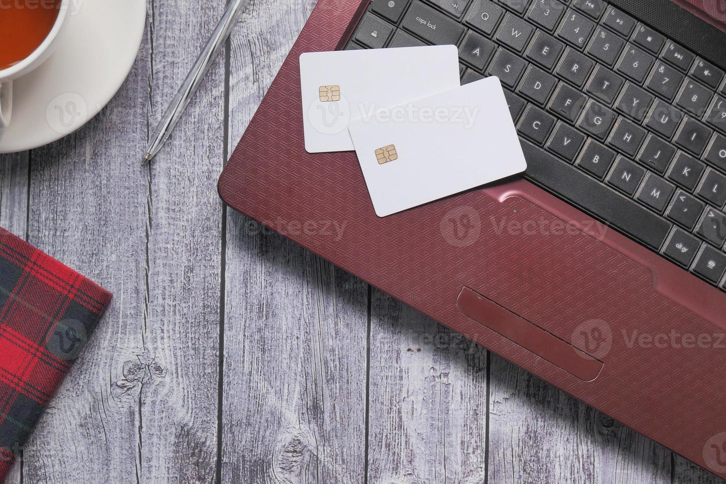 Tarjetas de crédito en un portátil sobre fondo de madera foto