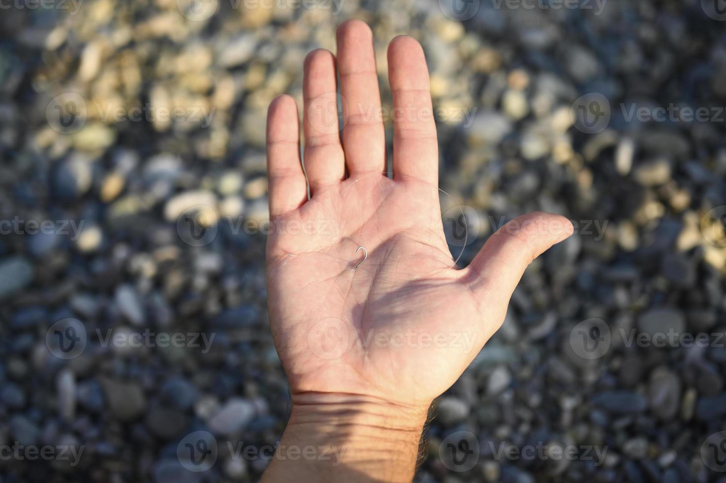 Man's hands tying a fishing line on a fishing hook photo