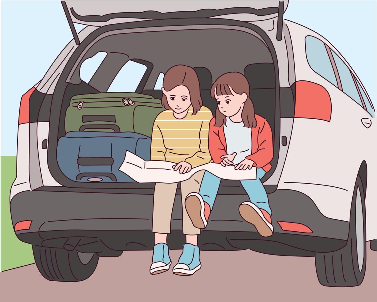 Cute little sisters are sitting in the trunk behind the car and looking at the map. vector
