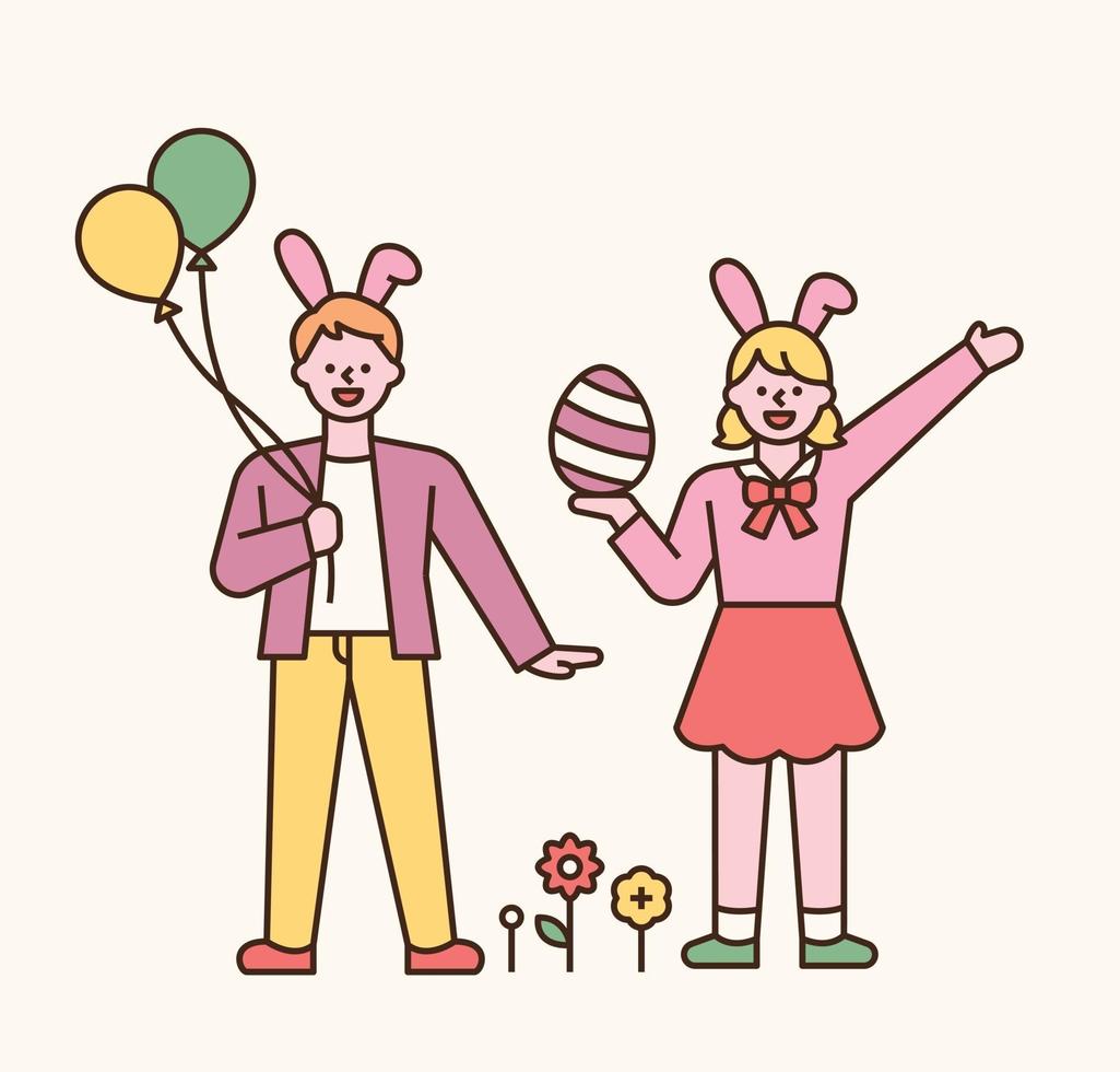 personajes de pascua. niño y niña en diademas de conejo. tienen globos y huevos de pascua en sus manos. Ilustración de vector mínimo de estilo de diseño plano.