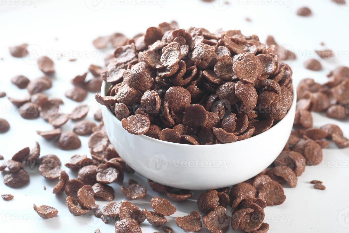 Close up of chocolate corn flakes in a bowl on white photo