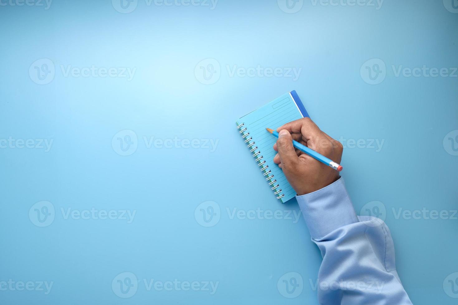 Hand writing in notepad on blue background photo