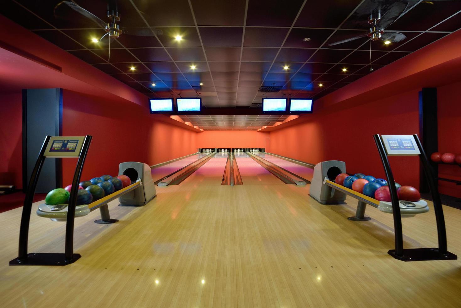 Bowling balls and wooden lanes in a bowling hall photo