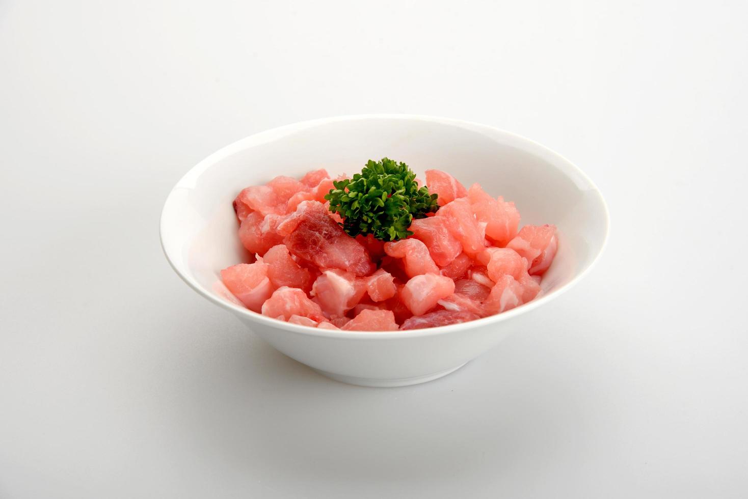 White bowl of raw diced beef meat isolated on a white background photo