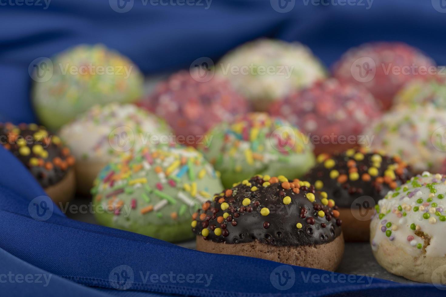 donas pequeñas y dulces de colores con chispitas foto