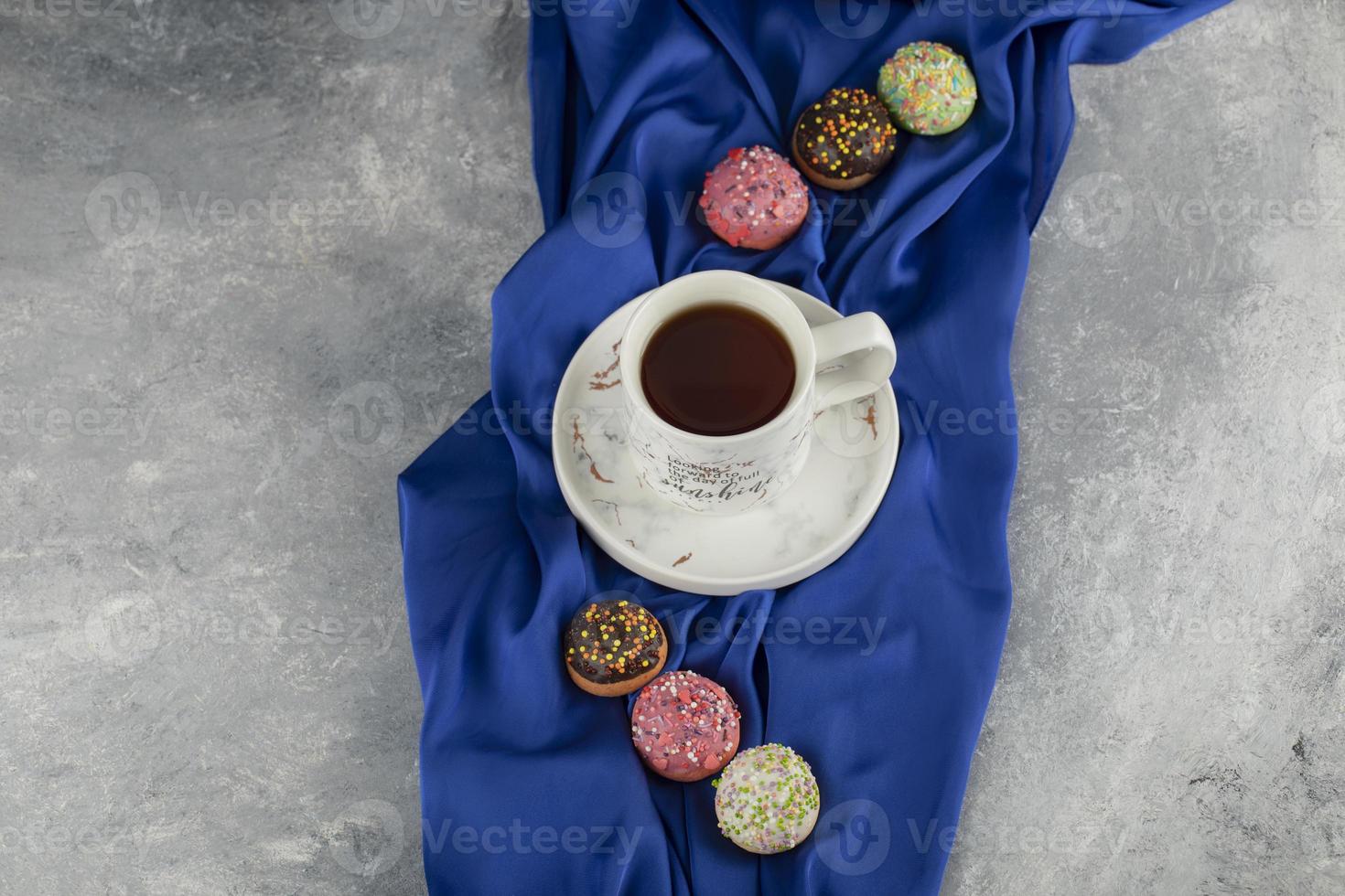 deliciosas donas coloridas con una taza de té foto