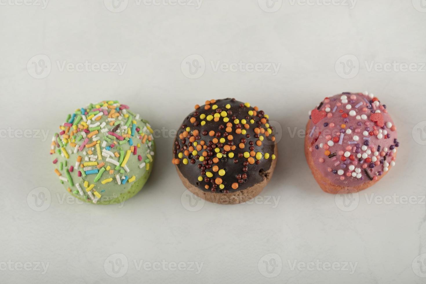 Colorful sweet small doughnuts on a white background photo