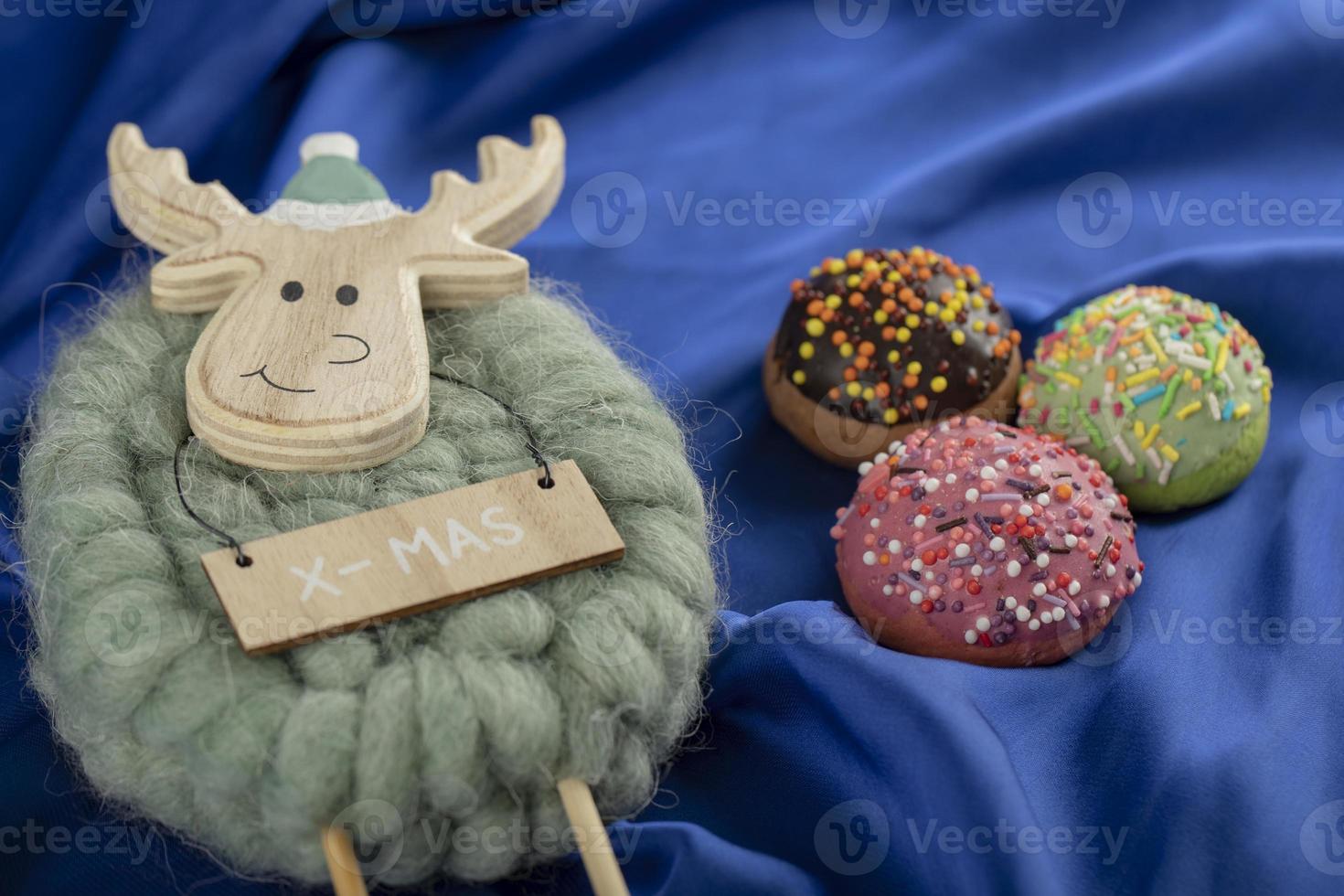 Colorful sweet doughnuts with a Christmas deer toy photo