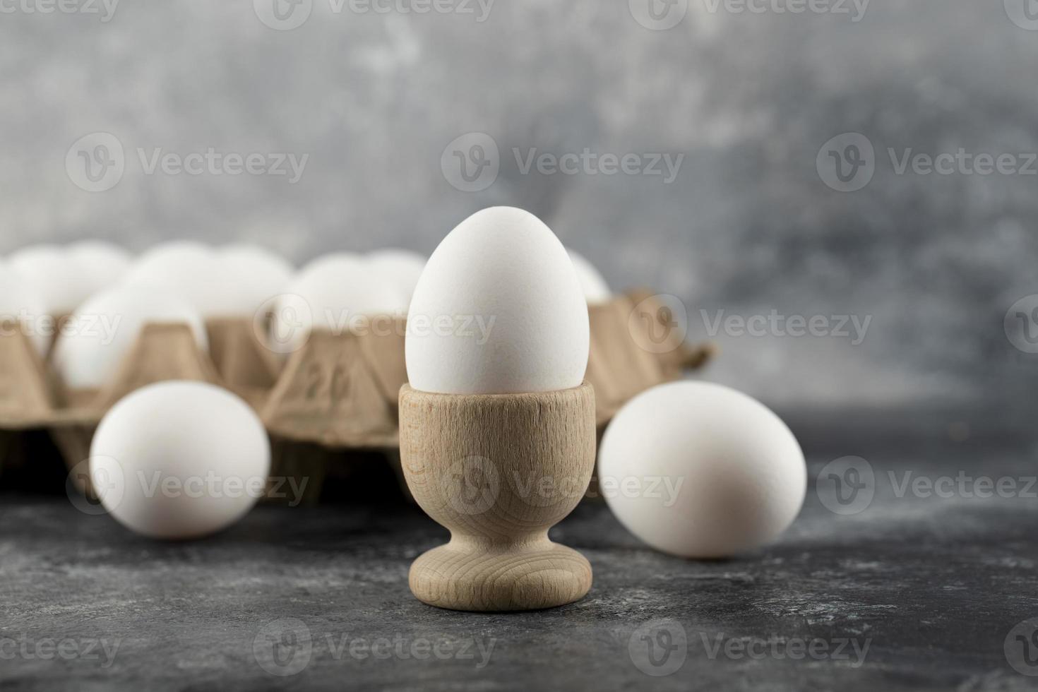 A wooden eggcup with a boiled chicken egg photo