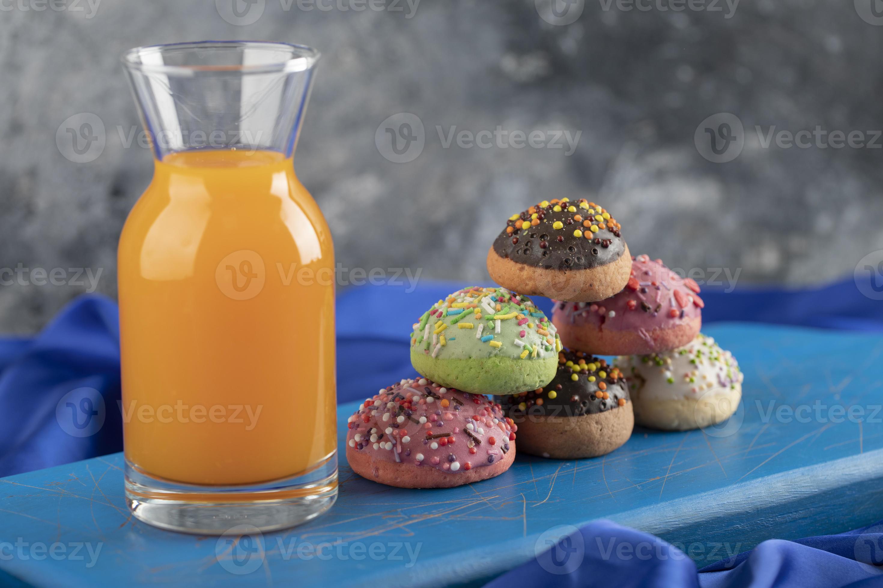 una botella de vidrio de jugo con rosquillas de colores foto
