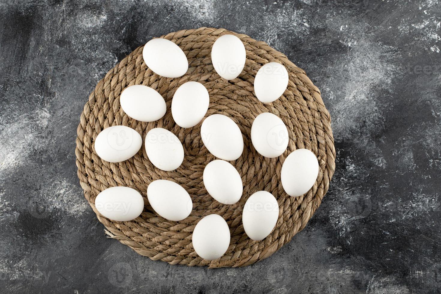 Huevos de gallina cruda blanca sobre una tela de saco foto