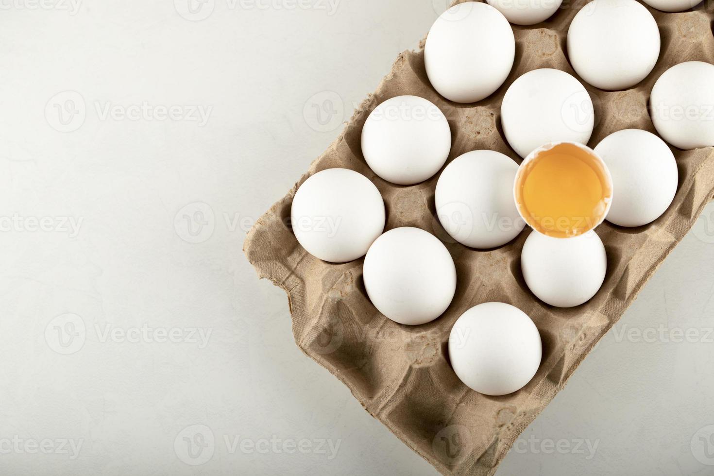 Raw chicken eggs in an egg box on a white background photo