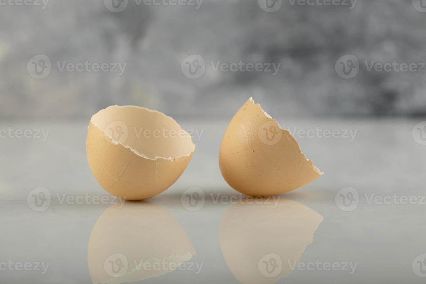 Broken brown eggshells on a marble background photo