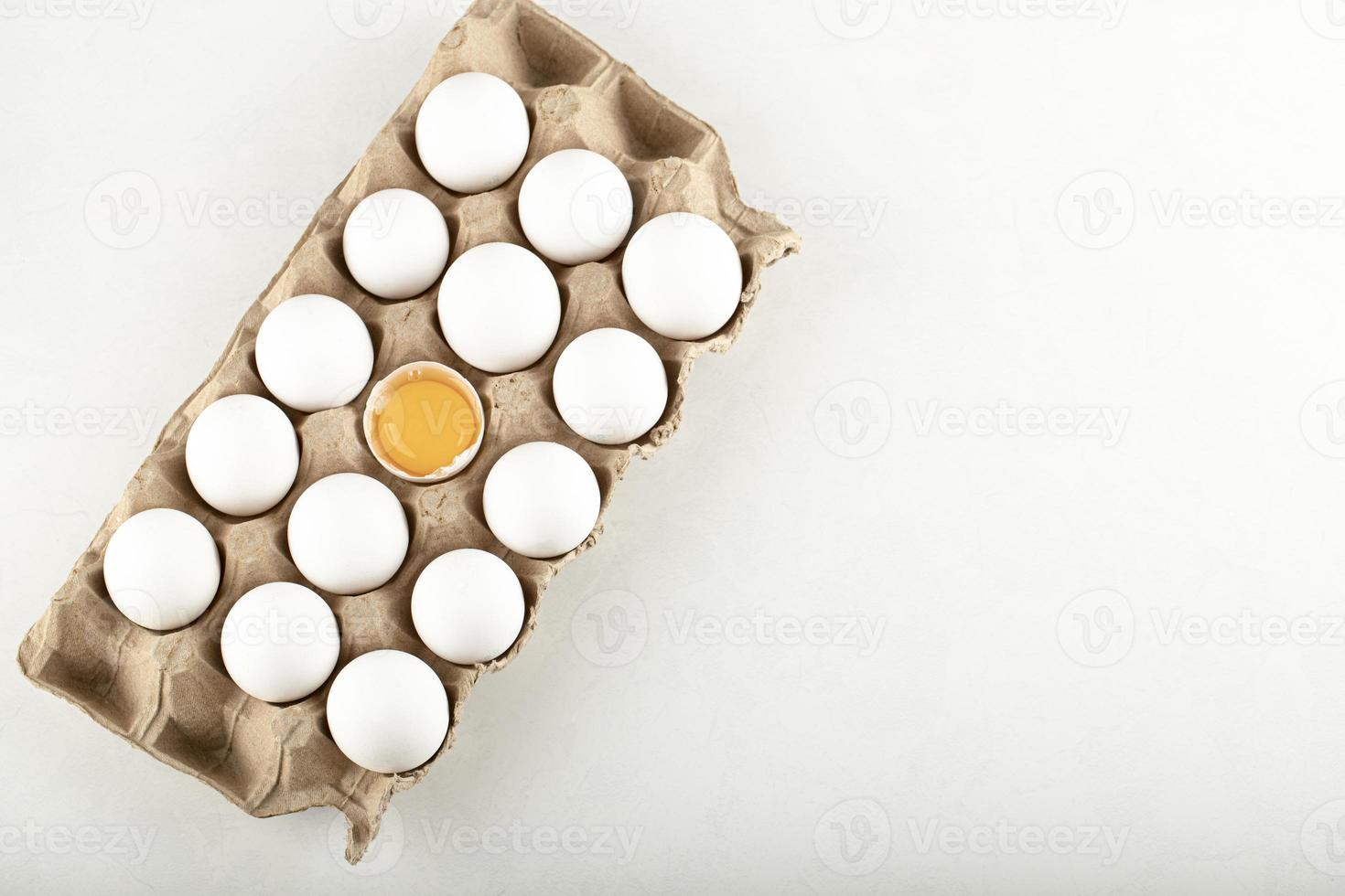 Raw chicken eggs in a carton container photo